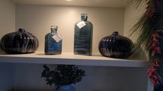 three vases are sitting on a shelf