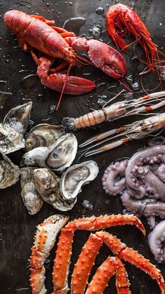 lobsters, clams and other seafood are on the table in preparation to be cooked