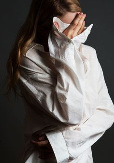 a woman covers her face with a white shirt