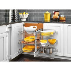 a kitchen with white cabinets and yellow dishes