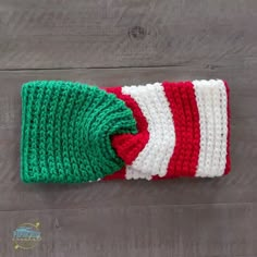 a red and white striped knitted hat on top of a wooden floor