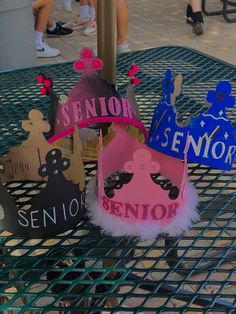 some little hats that are sitting on a metal table with people in the back ground