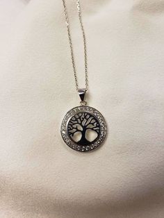 "This Tree of Life pendant is offered in Sterling Silver with a circular ring of Cubic Zirconias surrounding the tree. The round pendant measures 3/4\" in diameter and the chain is a 16\" andjustable to 18\". The tree of life is a symbol of a fresh start on life, positive energy, good health and a bright future. As a symbol of immortality. A tree grows old, yet it bears seeds that contain its very essence and in this way, the tree becomes immortal. As a symbol of growth and strength. The Tree of Cubic Zirconia Open Circle Necklace Gift, Hypoallergenic Stainless Steel Round Necklace, Tree Of Life Round Jewelry For Anniversary, Tree Of Life Jewelry Gift, Jewish Star, Bat Mitzvah Gifts, The Tree Of Life, A Fresh Start, Tree Of Life Pendant