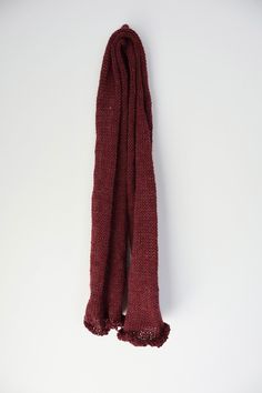 a red scarf hanging on a white wall