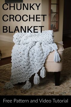 the chunky crochet blanket is sitting on a chair with text overlay that reads