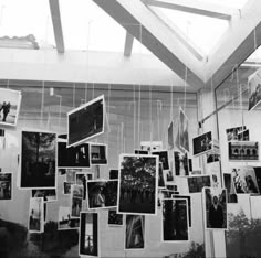 black and white photo hanging on the wall with many pictures hung from it's ceiling