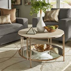 a living room with two couches and a coffee table in the middle, surrounded by pillows