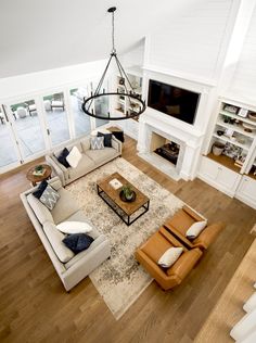 a living room filled with furniture and a flat screen tv mounted on the wall over a fireplace