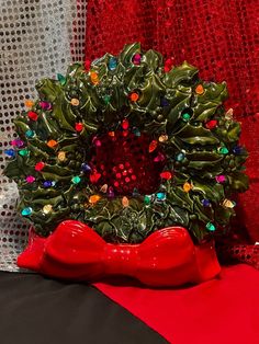 a christmas wreath sitting on top of a red cloth