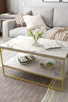 a living room with a couch, coffee table and pictures on the wall