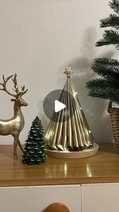 a christmas tree and other decorations on a table next to a vase with a deer in it