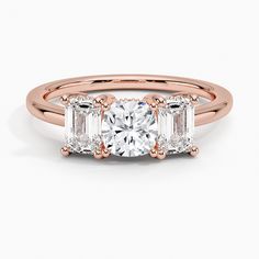 a rose gold engagement ring with three baguets