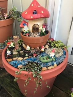 a potted planter filled with plants and gnome figurines sitting on top of it