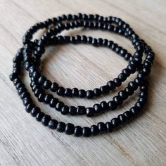 These bracelets are made up of glass seed beads in an opaque black color. Perfect for stacking together, wearing alone, or pairing with a chunky bracelet. The options are endless! (Bracelets sold individually). Great as gifts! Size shown: 7 inches Strung on pre-stretched bracelet material. Affordable Black Beaded Bracelets For Birthday, Black Stretch Bracelet With Tiny Beads As Gift, Black Round Beads Friendship Bracelets, Black Friendship Bracelets With Round Beads, Black Beaded Bracelet With Tiny Beads As Gift, Adjustable Black Beaded Bracelets With Tiny Beads, Handmade Black Friendship Bracelets With Round Beads, Black Round Beads Bohemian Friendship Bracelets, Minimalist Hand-strung Black Beaded Bracelets