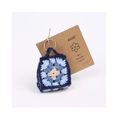 a crocheted keychain with a blue and white flower in the center