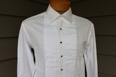 "-Unknown maker- R. Charles, LTD. (Alpharetta, Georgia) all cotton Medium - Large, nor labeled for size (please rely on measurements provided) 1990's or newer Unknown maker formal shirt with retailer label. A custom / made-to-order shirt, possibly Individualized Shirt Co. of New Jersey. Pure White, patterned weave cotton with fine vertical ribs. A very well made shirt. Pearl buttons which are hand applied. I recently ordered some dress shirts from Individualized thru a local clothier...Starting range in the bottom tier fabrics is $250...It only goes up from there. Please note: This shirt requires four (4) shirt studs and a pair of cuff links (neither are included). I have no information on R, Charles, LTD., the retailer, I can only assume they are longer in business. 3\" Medium spread coll Classic Pleated Shirt For Formal Occasions, Fitted Collar Dress Shirt For Formal Occasions, Formal Fitted Dress Shirt With Collar, Fitted Formal Dress Shirt With Collar, Fitted Classic Pleated Tops, Vintage Formal Shirt With Button Closure, Classic Pleated Button-up Top, Fitted Vintage Tops For Semi-formal Occasions, Vintage Fitted Tops For Semi-formal Occasions