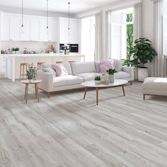 a living room with white furniture and wood flooring