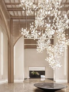 a large chandelier hanging from the ceiling in a room with white walls and flooring