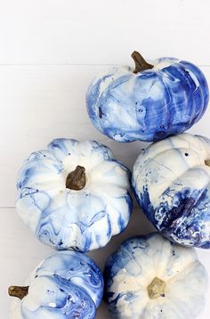 blue and white painted pumpkins sitting on top of each other