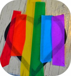 several different colored pieces of cloth on a wooden surface