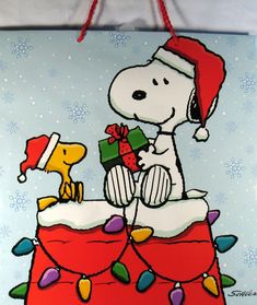 a painting of a snoopy dog on top of a christmas cake holding a present