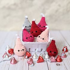 small crocheted gnomes in a white container surrounded by candy and candies