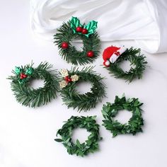 christmas wreaths and decorations laid out on a white surface