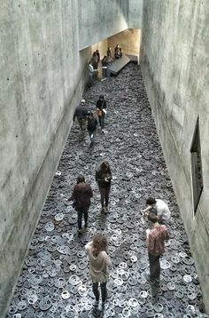 several people are walking through a tunnel with lots of coins on the floor in front of them