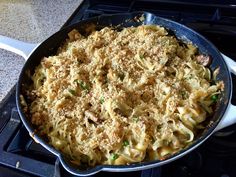 a skillet filled with macaroni and cheese sitting on top of a stove