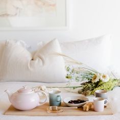 a tray that has some cups on top of it and a tea pot next to it