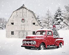 an old red truck is parked in front of a barn and christmas tree on a snowy day