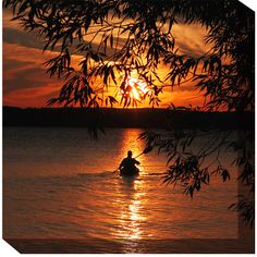 a person in a boat on the water at sunset