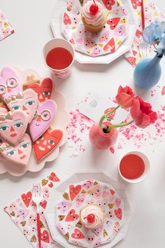 valentine's day table setting with cupcakes, heart shaped cookies and flowers