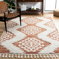 an orange and white rug with tassels on the floor next to a chair