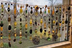 a window covered in lots of different colored glass beads and chains hanging from it's side