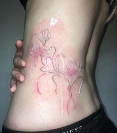 a woman's stomach with pink flowers on it and the bottom part of her body covered in plastic