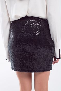 Introducing our Mini Bodycon Skirt in Black Small Sequins – a super fashionable piece that adds a touch of glamour to your wardrobe. This mini skirt features a bodycon fit, accentuating your curves and creating a chic and elegant style. The super small sequins add a subtle yet eye-catching texture, making it perfect for various fashionable events.  The mini length of the skirt makes it versatile, allowing you to pair it with one of our matching sequin tops for a coordinated look or with a blouse for a sophisticated ensemble.  Crafted from a blend of 95% polyester and 5% elastane, this skirt offers both comfort and flexibility. The zip fastening ensures easy wear, and the high waist rise adds a modern touch to the overall silhouette.  The model is wearing size S, and with measurements of 33 Sequined Fabric, Classic Blouses, Bodycon Skirt, Style Party, Style Upgrade, Sequin Mini, Black Mini Skirt, Body Con Skirt, Knitwear Tops