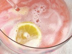 a glass filled with liquid and a lemon slice