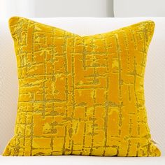 a yellow pillow sitting on top of a white couch