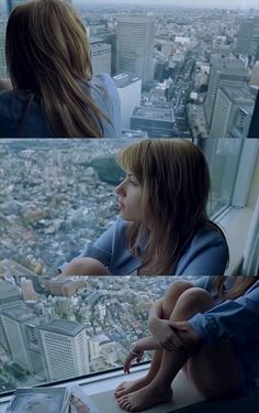 two girls looking out the window at cityscape and skyscrapers from an observation platform