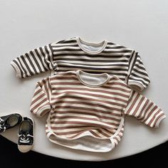 This striped tee is an excellent choice for a casual outfit during the spring and autumn seasons. Crafted from soft and breathable cotton, it features long sleeves, making it ideal for cooler weather. The top is designed for children and has a regular length, ensuring a comfortable fit for any activity. The V-neck collar adds a stylish touch to this unisex item, making it a versatile addition to any wardrobe. It is recommended to select your usual size as the fit is true to size. Details: Tops T Winter Striped Long Sleeve T-shirt, Cotton Streetwear T-shirt With Three Stripes, Kids Long Sleeve Shirt, Cotton Long Sleeve T-shirt With Striped Sleeves, T Shirt 2023, Long Sleeve Cotton T-shirt With Horizontal Stripes, Korean Boys, Baby Long Sleeve, Striped T Shirt