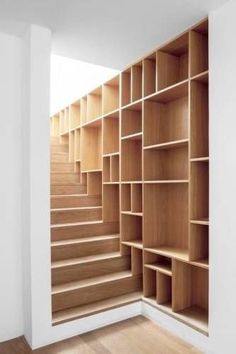 an empty room with wooden shelves and stairs