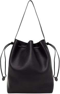 Polished saddle calfskin tote in black. · Fixed shoulder strap · Gold-tone logo stamp at side · Drawstring closure · Zip and patch pocket at interior · H14.5 x W12 x D7 Supplier color: Black Black Calf Leather Bucket Bag With Adjustable Strap, Black Calf Leather Top Handle Bucket Bag, Designer Black Bucket Bag For Work, Luxury Black Calf Leather Bucket Bag, Black Calf Leather Bucket Bag With Detachable Strap, Black Calf Leather Shoulder Bag With Removable Pouch, Black Calf Leather Bucket Tote Bag, Black Calf Leather Bucket Bag, Black Calf Leather Bag For Work