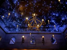 a chandelier hanging from the ceiling in a room filled with stars and lights