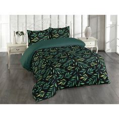 a bed with green and black leaves on it