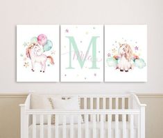 two unicorns are hanging on the wall next to a baby's crib