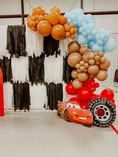 balloons and cars are on display at a birthday party