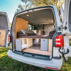 the back end of a white van with its open door and bed in it's trunk