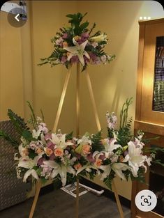 an arrangement of flowers on a stand in a room