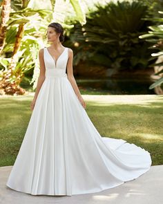 a woman in a white wedding dress standing outside